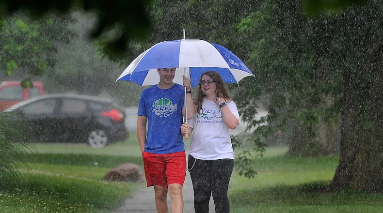 Two people walk along Shroyer Road in the rain Tuesday afternoon, June 30, 2020. MARSHALL GORBY / STAFF