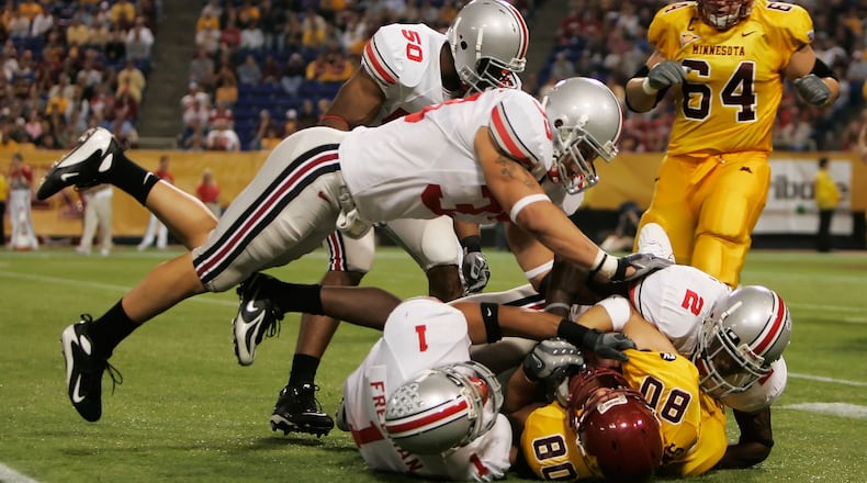 MINNEAPOLIS, MN - SEPTEMBER 29:  James Laurinaitis #33 of the Ohio State Buckeyes jumps to assist his teammates Marcus Freeman #1 and Malcolm Jenkins #2 to tackle Jack Simmons #80  of the Minnesota Golden Gophers in the third quarter at the Metrodome on September 29, 2007 in Minneapolis, Minnesota.  Ohio State defeated Minnesota 30- 7.  (Photo by Jeff Gross/Getty Images)    2