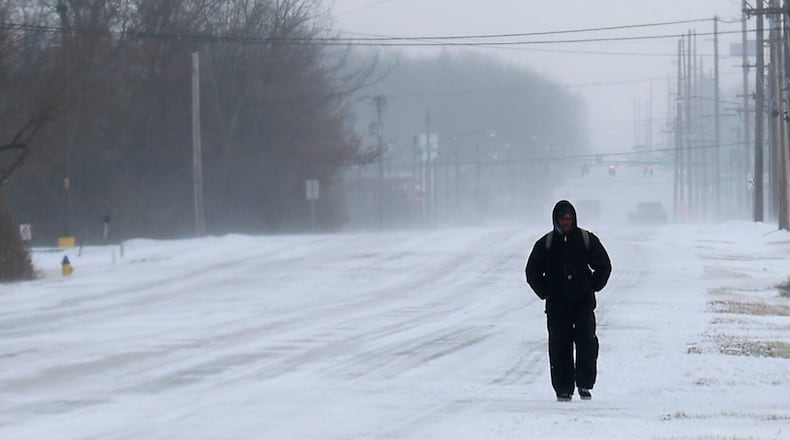 A man walks through the blowing snow as makes his way along Leffel Lane in Springfield Friday, Dec. 23, 2022. BILL LACKEY/STAFF