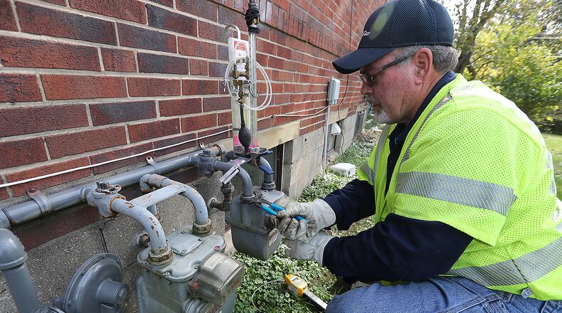 Bill Farley, Columbia Gas customer service worker, turns on the gas at a Springfield residence in this file photo.