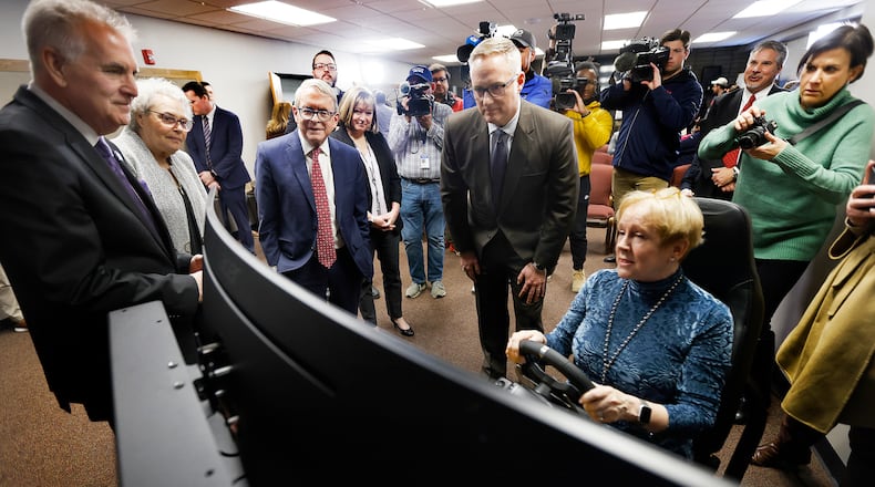 Ohio Gov. Mike DeWine was joined by Dom Tiberi of the Maria Tiberi Foundation to announce a new driver training initiative Thursday, Dec. 5, 2024 at the High Street Church of the Nazarene Clark County. The initiative will primarily focus on teaching members of the migrant population the skills of safe driving. Dom Tiberi (left) and his wife, Maria, who have donated several driving simulators, stand with DeWine and Springfield Mayor Rob Rue while they watch Van Burns operate one of the simulators. MARSHALL GORBY\STAFF