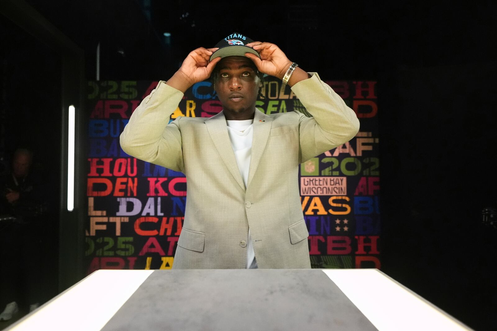 Miami quarterback Cam Ward puts on a hat after being chosen by the Tennessee Titans with the first overall pick during the first round of the NFL football draft, Thursday, April 24, 2025, in Green Bay, Wis. (AP Photo/Jeff Roberson)
