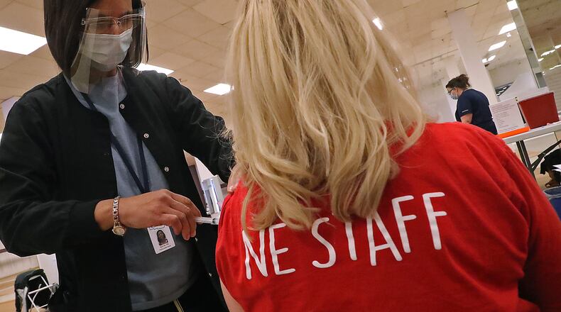 A member of the Northeastern High School staff gets the COVID-19 vaccine from nurse Salimah Berrien in the Clark County vaccine distribution center at the Upper Valley Mall on Feb. 10. BILL LACKEY/STAFF