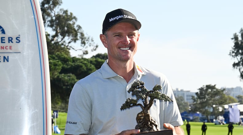Justin Rose, of England, holds the winner's trophy at the Farmers Insurance Open golf tournament Sunday, Feb. 1, 2026, at Torrey Pines in San Diego. (AP Photo/Denis Poroy)