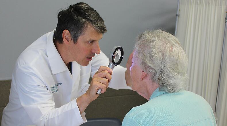 Dr Thomas Rak performs a health screening for skin cancer at a recent CRSI health fair in Urbana. Clark State will host a health fair next week. JEFF GUERINI/STAFF