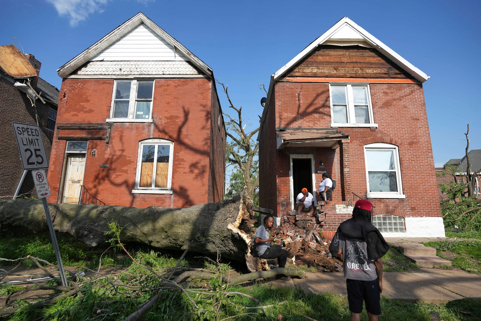 People survey damage after a severe storm moved through Friday, May 16, 2025, in St. Louis. (AP Photo/Jeff Roberson)