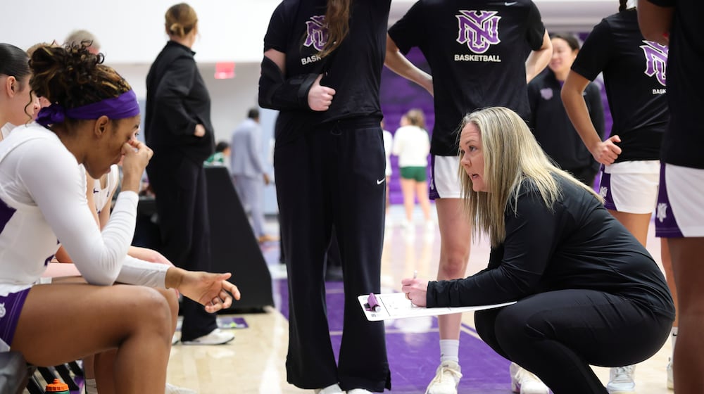 In this image provided by NYU Athletic Communications, NYU coach Meg Barber, right, talks to her players during an NCAA Div III college basketball game against Carnegie Mellon, Sunday, Feb. 1, 2026, in New York. (NYU Athletic Communications via AP)