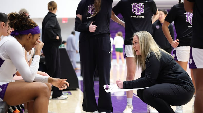 In this image provided by NYU Athletic Communications, NYU coach Meg Barber, right, talks to her players during an NCAA Div III college basketball game against Carnegie Mellon, Sunday, Feb. 1, 2026, in New York. (NYU Athletic Communications via AP)
