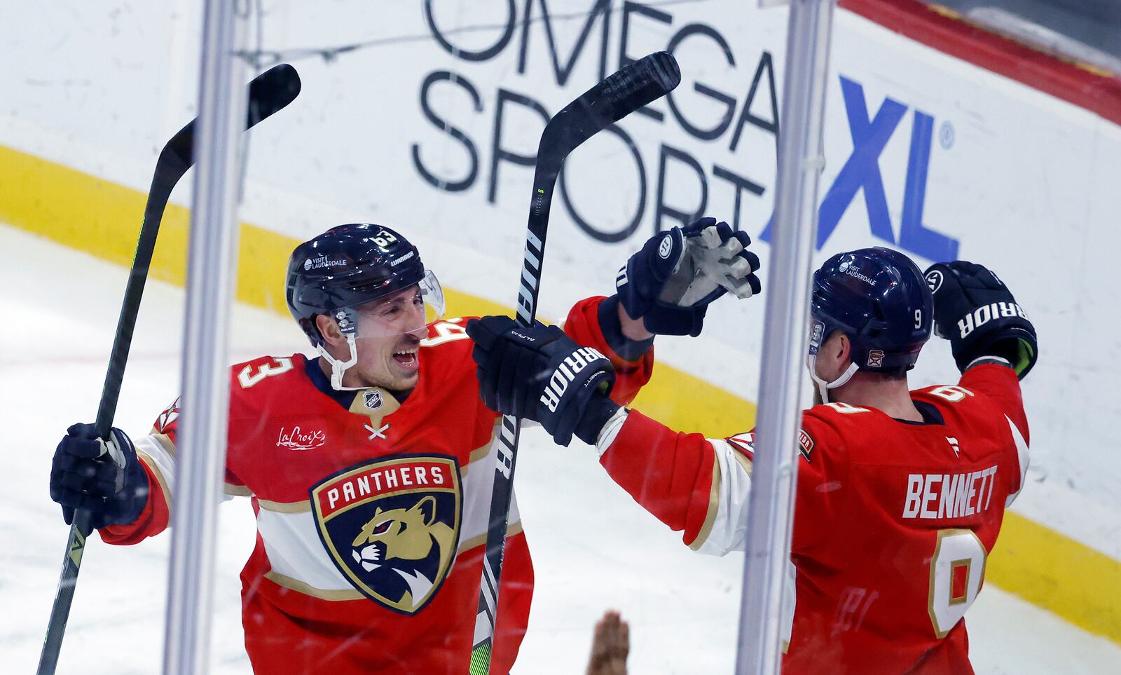 Florida Panthers center Brad Marchand (63) and center Sam Bennett (9) celebrate during overtime of an NHL hockey game against the Utah Hocket Club, Friday, March 28, 2025, in Sunrise, Fla. (AP Photo/Rhona Wise)