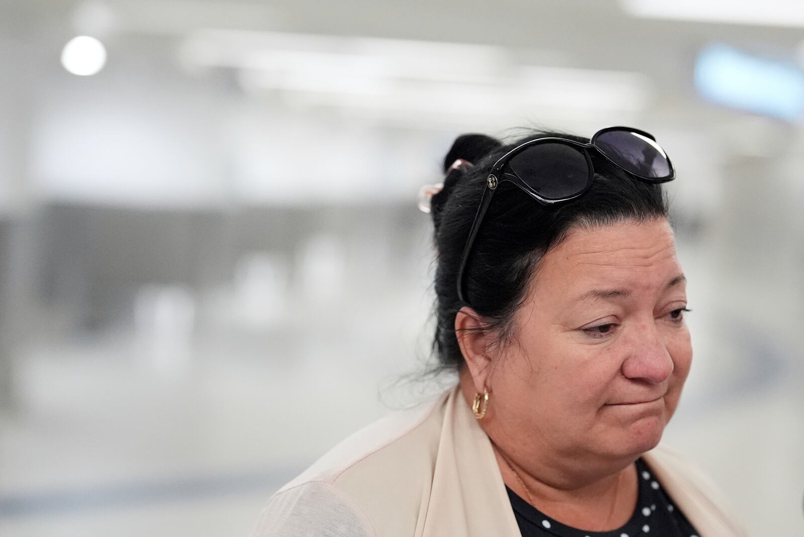 Magda Moreno, 58, a Cuban-American who had just arrived back from Havana, reacts as she speaks to journalists about a travel ban affecting some Cubans, at Miami International Airport, Monday, June 9, 2025, in Miami. (AP Photo/Rebecca Blackwell)