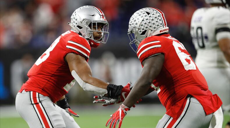 INDIANAPOLIS, INDIANA - DECEMBER 01: Jonathan Cooper #18 and Robert Landers #67 of the Ohio State Buckeyes celebrate after a defensive play against the Northwestern Wildcats in the second quarter at Lucas Oil Stadium on December 01, 2018 in Indianapolis, Indiana. (Photo by Joe Robbins/Getty Images)
