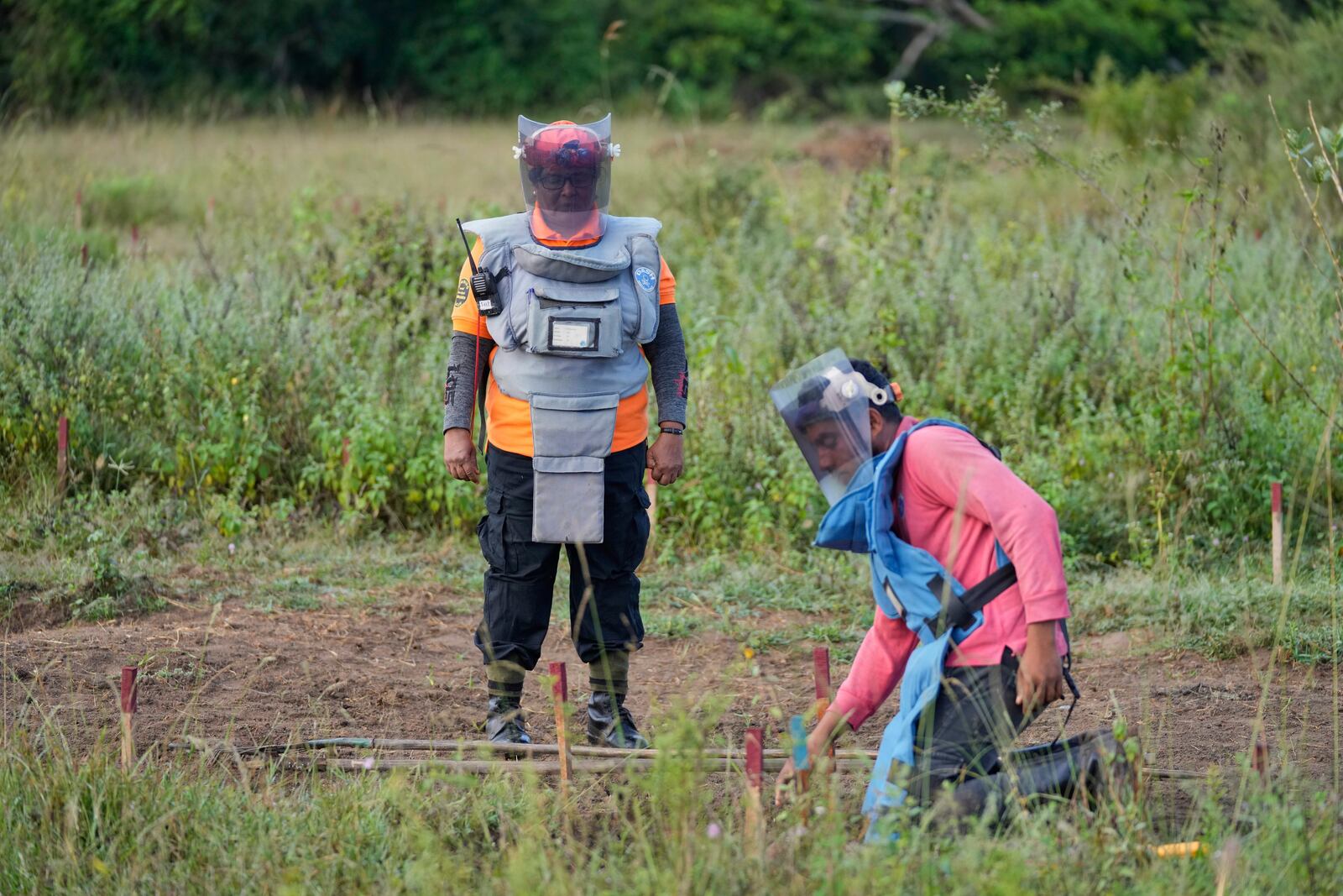 Thavarathnam Pushparani, left, monitors a fellow worker as they work in a contaminated mining area in Mankulam, Sri Lanka, Thursday, April 3, 2025. (AP Photo/Eranga Jayawardena)