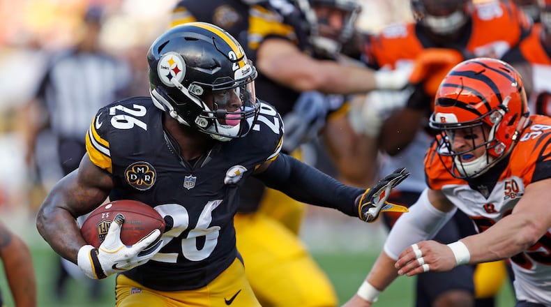 Pittsburgh Steelers running back Le’Veon Bell (26) gets past Cincinnati Bengals defensive end Carl Lawson (58) during the first half of an NFL football game in Pittsburgh, Sunday, Oct. 22, 2017. (AP Photo/Keith Srakocic)