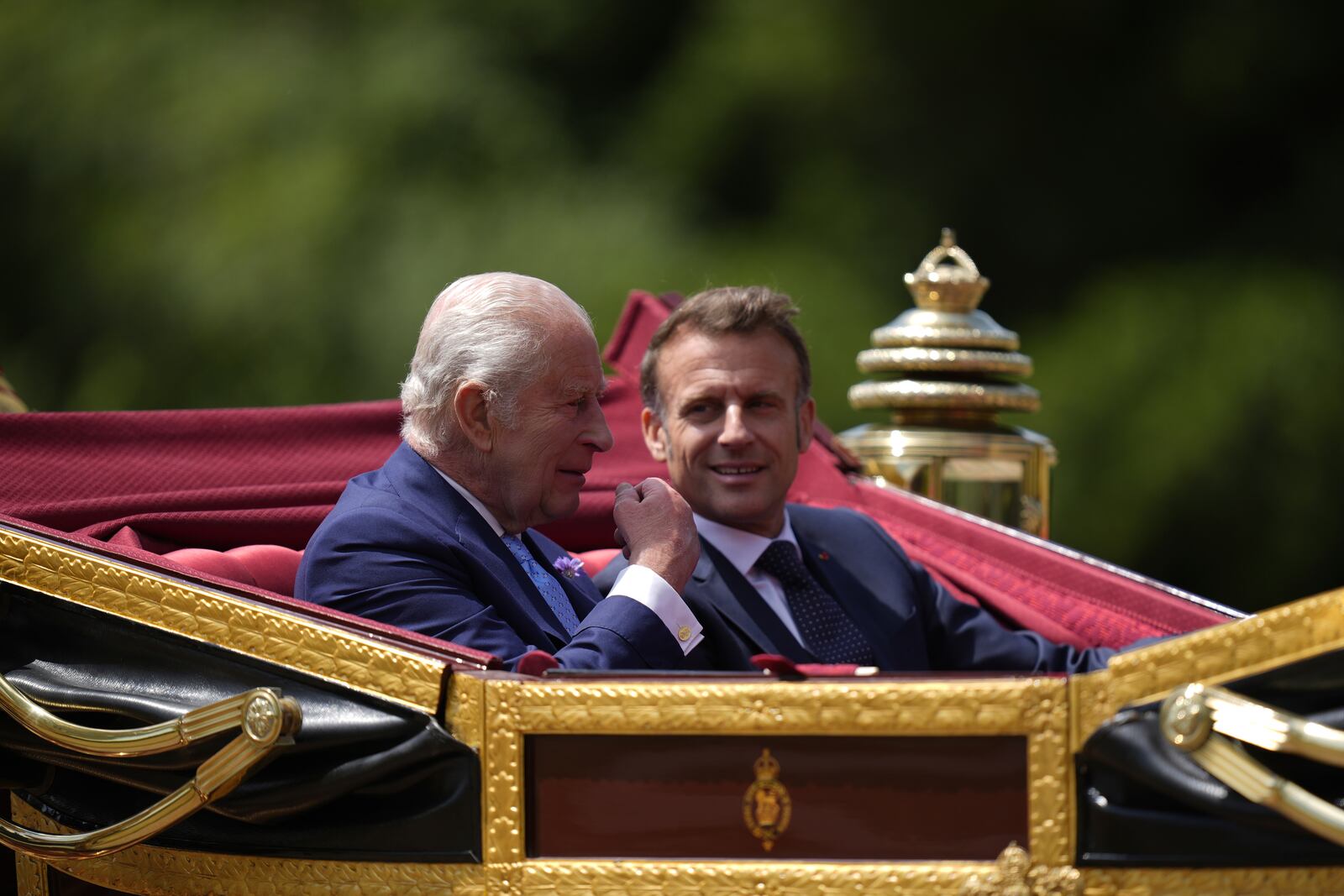 Britain's King Charles III and France's President Emmanuel Macron, right, travel in a 1902 State Landau on a state drive to Windsor Castle in Windsor, England, Tuesday July 8, 2025, on the first day of a three-day state visit to Britain. (Andrew Matthews/Pool via AP)