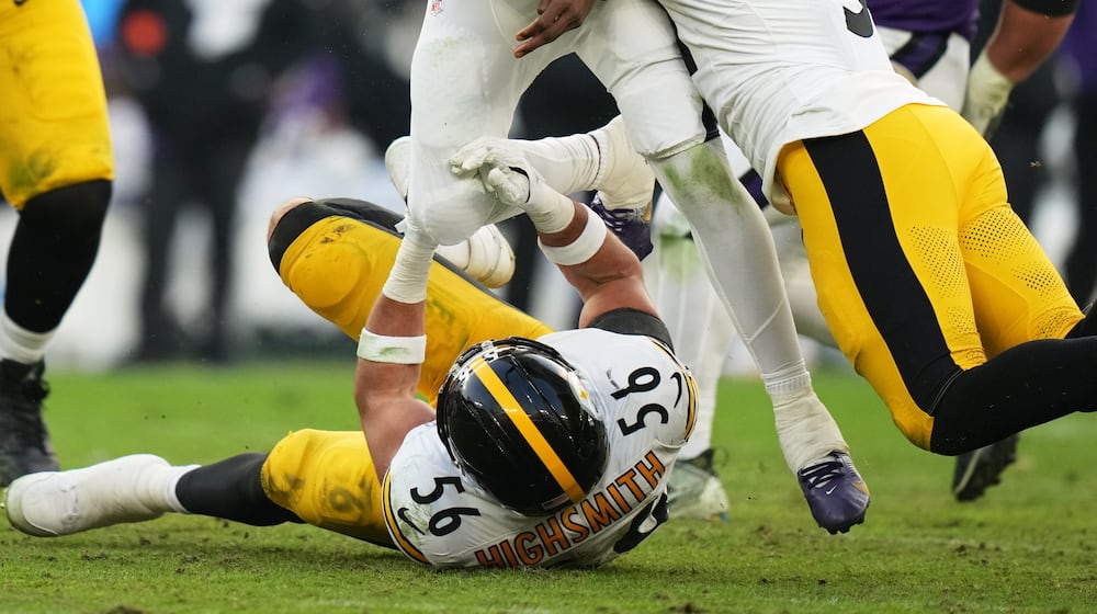 Pittsburgh Steelers linebacker Alex Highsmith (56) and linebacker Nick Herbig (51) tackle Baltimore Ravens quarterback Lamar Jackson (8) during the second half of an NFL football game, Sunday, Dec. 7, 2025, in Baltimore. (AP Photo/Stephanie Scarbrough)