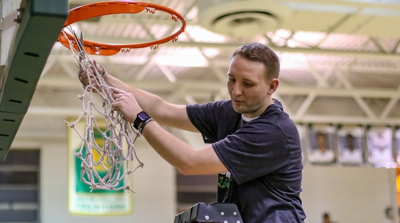 Catholic Central High School basketball coach Cody Sarensen cuts down the net after the Irish beat Cedarville on Feb. 5 to clinch their second straight Ohio Heritage Conference South Division title. Sarensen recently resigned to join the coaching staff at Wittenberg University. CONTRIBUTED PHOTO BY MICHAEL COOPER