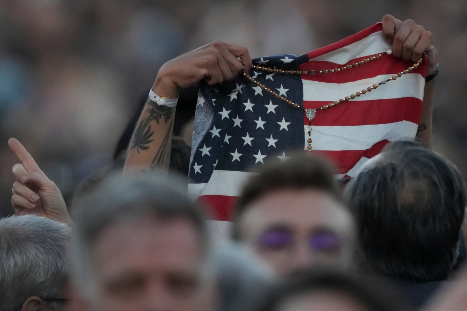 FILE - Faithful holds an American flag following the election of Pope Leo XIV at the Vatican, Thursday, May 8, 2025. (AP Photo/Andrew Medichini, File)