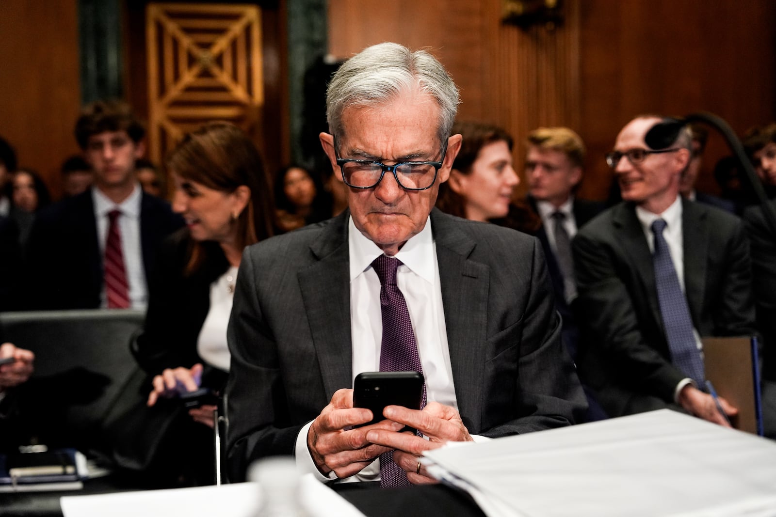 Federal Reserve Board Chairman Jerome Powell uses his phone before a Senate Committee on Banking hearing, Wednesday, June 25, 2025, on Capitol Hill in Washington. (AP Photo/Julia Demaree Nikhinson)