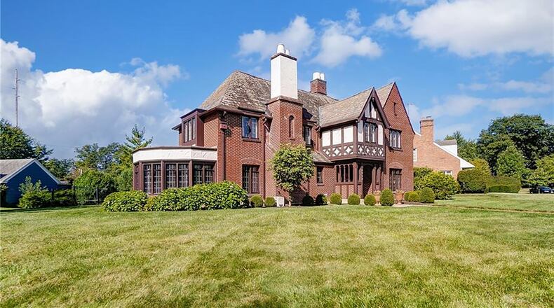 The historic brick two story home has a covered front portico, brick paver walk and formal entry inside with wood flooring.