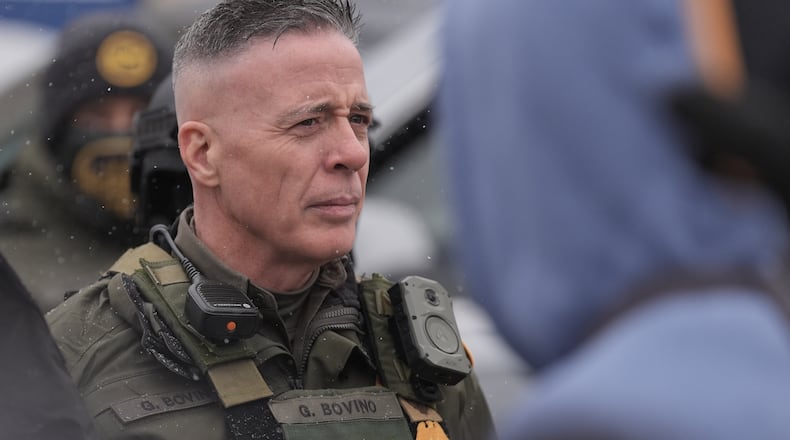 FILE - U.S. Border Patrol Cmdr. Gregory Bovino stands with Federal agents outside a convenience store, Jan. 21, 2026, in Minneapolis. (AP Photo/Angelina Katsanis, File)