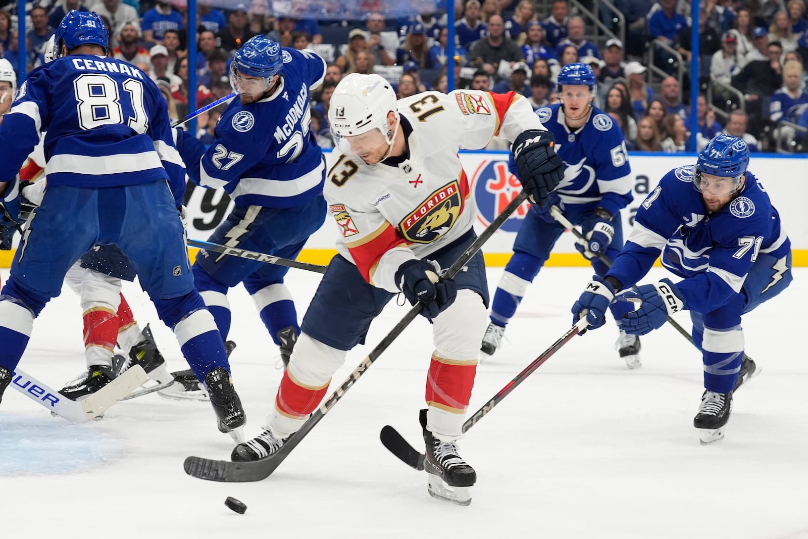 Florida Panthers center Sam Reinhart (13) tries to control the puck between Tampa Bay Lightning defenseman Erik Cernak (81) and center Anthony Cirelli (71) during the first period in Game 5 of an NHL hockey Stanley Cup first-round playoff series, Wednesday, April 30, 2025, in Tampa, Fla. (AP Photo/Chris O'Meara)