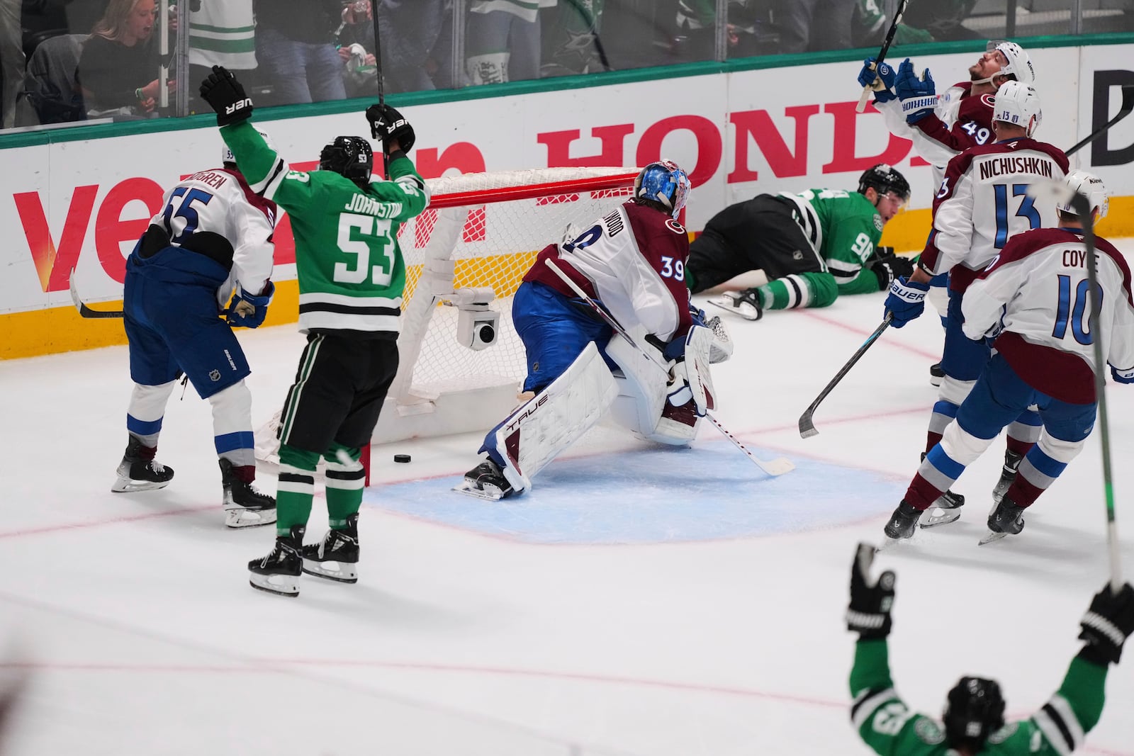 The Dallas Stars celebrate after Mikko Rantanen, laying against boards at rear, scored against the Colorado Avalanche's Mackenzie Blackwood (39) in the third period in Game 7 of a first-round NHL hockey playoff series Saturday, May 3, 2025, in Dallas. (AP Photo/Julio Cortez)