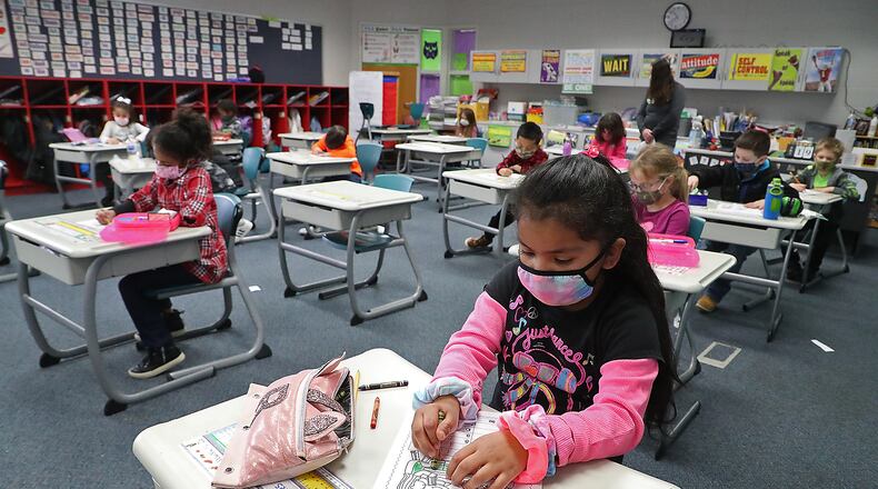 With masks and desks spaced apart, students at Simon Kenton Elementary work on classwork Friday, Feb. 19, 2021. BILL LACKEY/STAFF