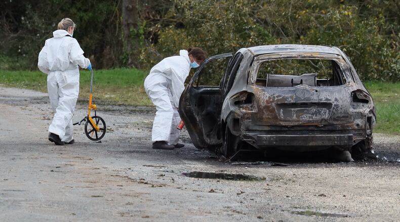 Investigators work by the burned car after a motorist deliberately rammed pedestrians and cyclists across two neighbouring towns on the Ile d'Oleron, off the Atlantic coast, injuring people before being detained by gendarmes, Wednesday, Nov. 5, 2025 in Saint-Pierre-d'Oleron. (AP Photo/Yohan Bonnet)