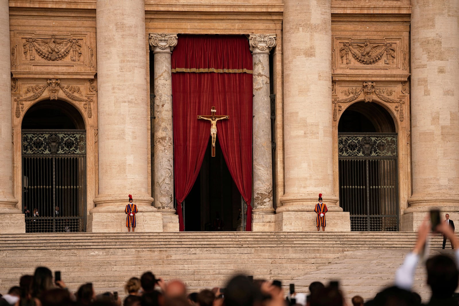People gather in St. Peter's Square as they await the arrival of the body of Pope Francis, who will lie in state at St. Peter's Basilica for three days, at the Vatican, Wednesday, April 23, 2025. (AP Photo/Andreea Alexandru)
