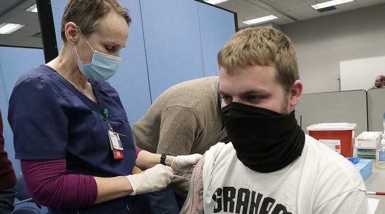 Cale Burdyshaw, a teacher in the Graham School Distict gets the COVID vaccine from Deborah McKee at the Champaign County Health District Friday. BILL LACKEY/STAFF