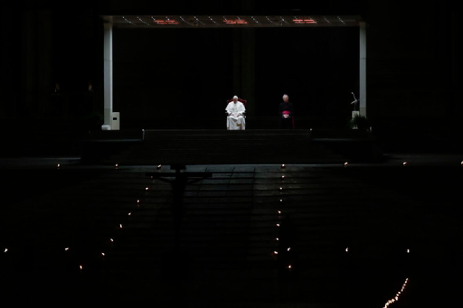 FILE - Pope Francis is flanked by Mons. Guido Marini, right, the Vatican master of liturgical ceremonies, as he leads the Via Crucis – or Way of the Cross – ceremony in St. Peter's Square empty of the faithful following Italy's ban on gatherings to contain coronavirus contagion, at the Vatican, Friday, April 10, 2020. (AP Photo/Alessandra Tarantino, File)