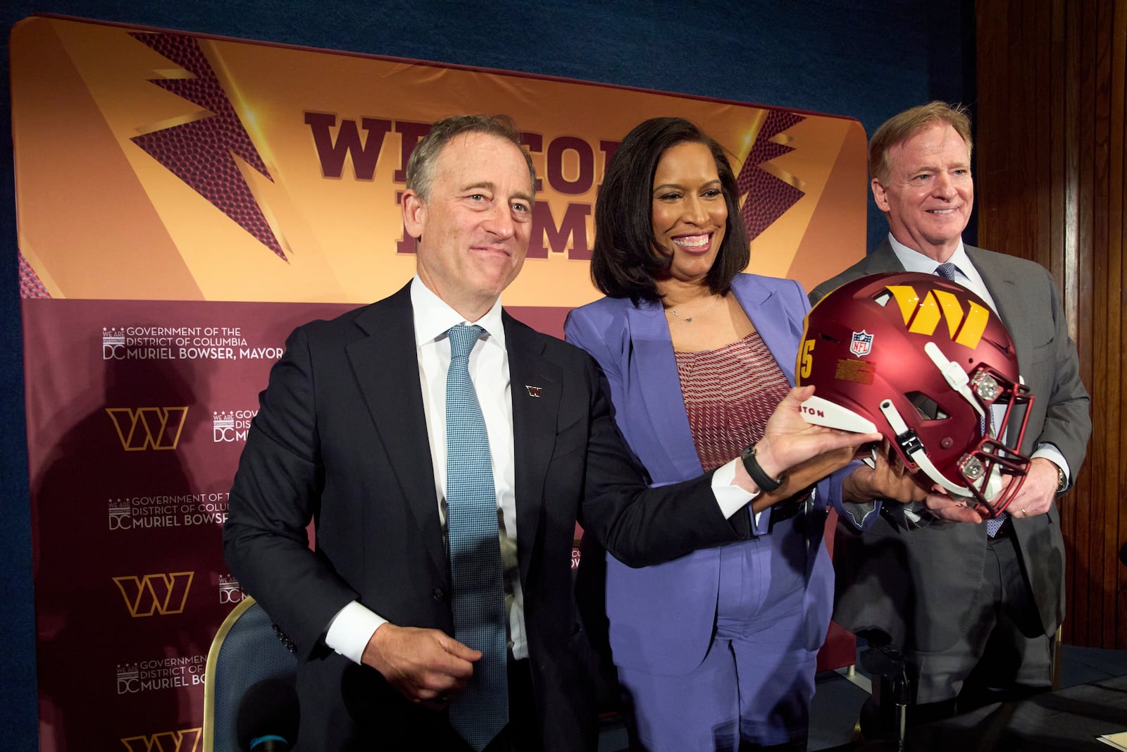 Washington Commanders controlling owner Josh Harris, from left, District of Columbia Mayor Muriel Bowser and NFL Commissioner Roger Goodell hold up a signed helmet after an announcement about a new home for the NFL football team on the site of the old RFK Stadium, Monday, April 28, 2025, at the National Press Club in Washington. (AP Photo/Jacquelyn Martin)
