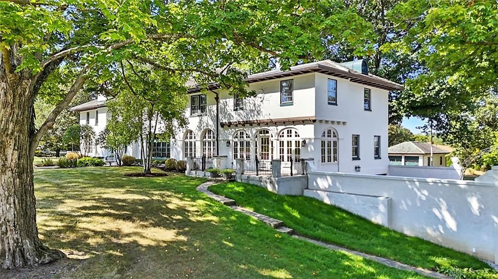 The rear of the home features multiple patios, and a uniquely designed Adirondack style house with fireplace. There is also a separate building with additional garage spaces. CONTRIBUTED