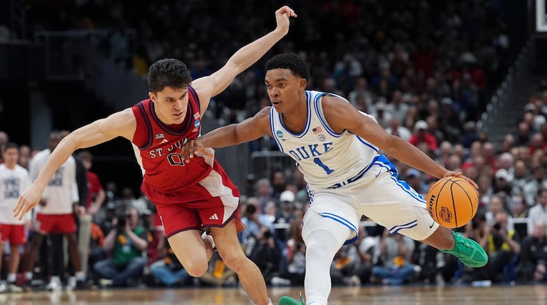 Duke guard Caleb Foster (1) drives past St. John's guard Dylan Darling (0) during the second half in the Sweet 16 of the NCAA college basketball tournament, Friday, March 27, 2026, in Washington. (AP Photo/Stephanie Scarbrough)