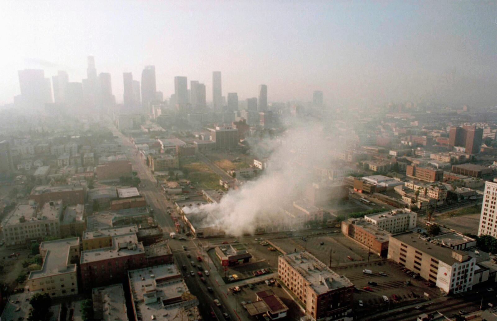 FILE - In this April 30, 1992 file photo, smoke rises from a shopping center burned by rioters in Los Angeles after four police officers had been acquitted of the 1991 beating of motorist Rodney King. (AP Photo/Paul Sakuma, File)
