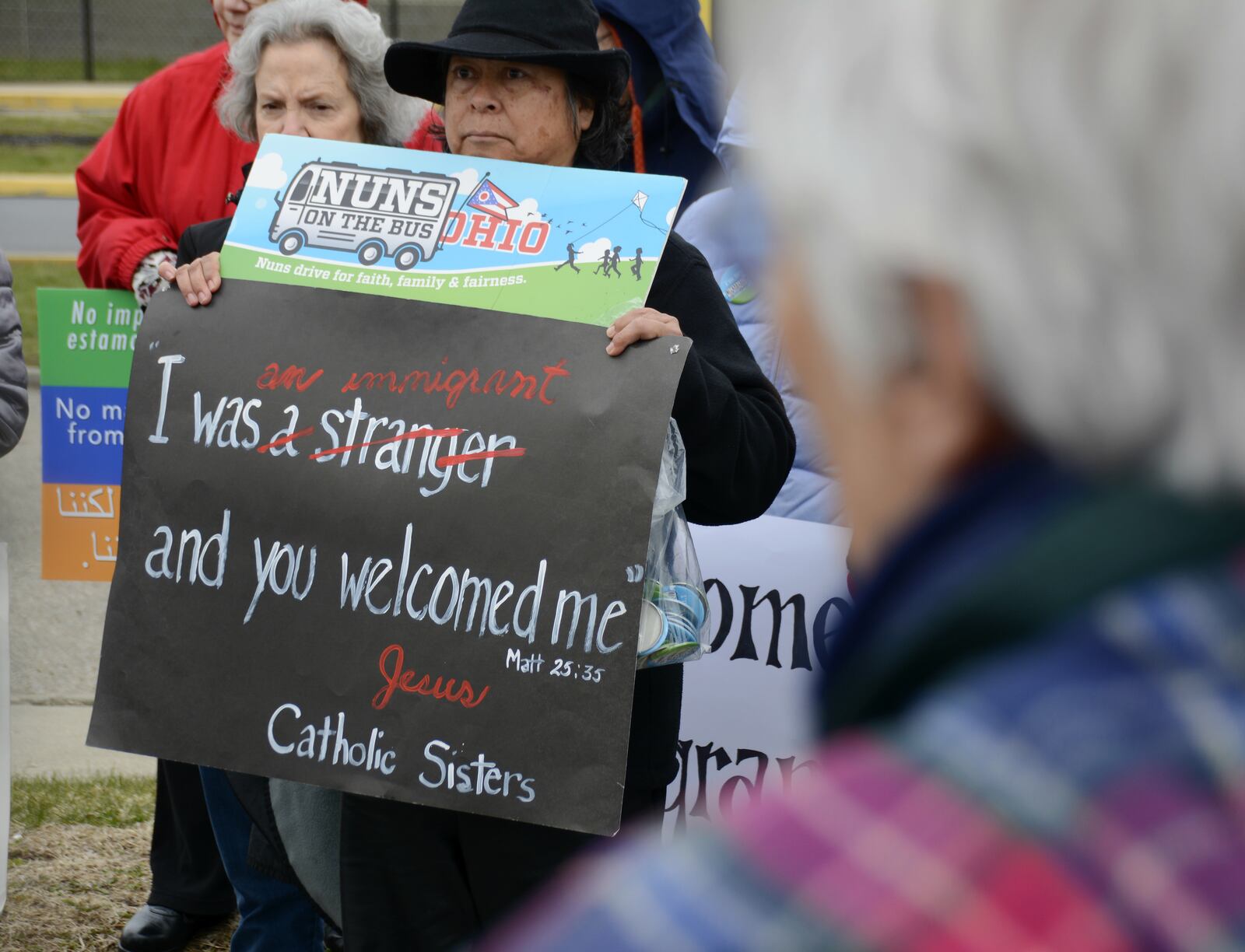 A protester holds a sign in front of the Butler County Jail on Tuesday afternoon, March 20, supporting the Ohio Nuns on the Bus mission of pushing for immigration reform. MICHAEL D. PITMAN/STAFF