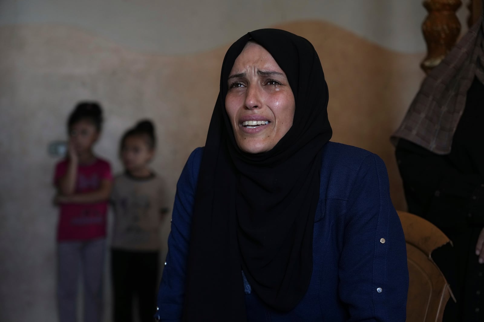 Iman Al-Nouri, the mother of two children who were killed, and one injured, in an Israeli strike while waiting to receive nutritional supplements at a medical clinic, reacts during an interview at her home in Deir al-Balah, Gaza Strip, Friday, July 11, 2025. (AP Photo/Abdel Kareem Hana)