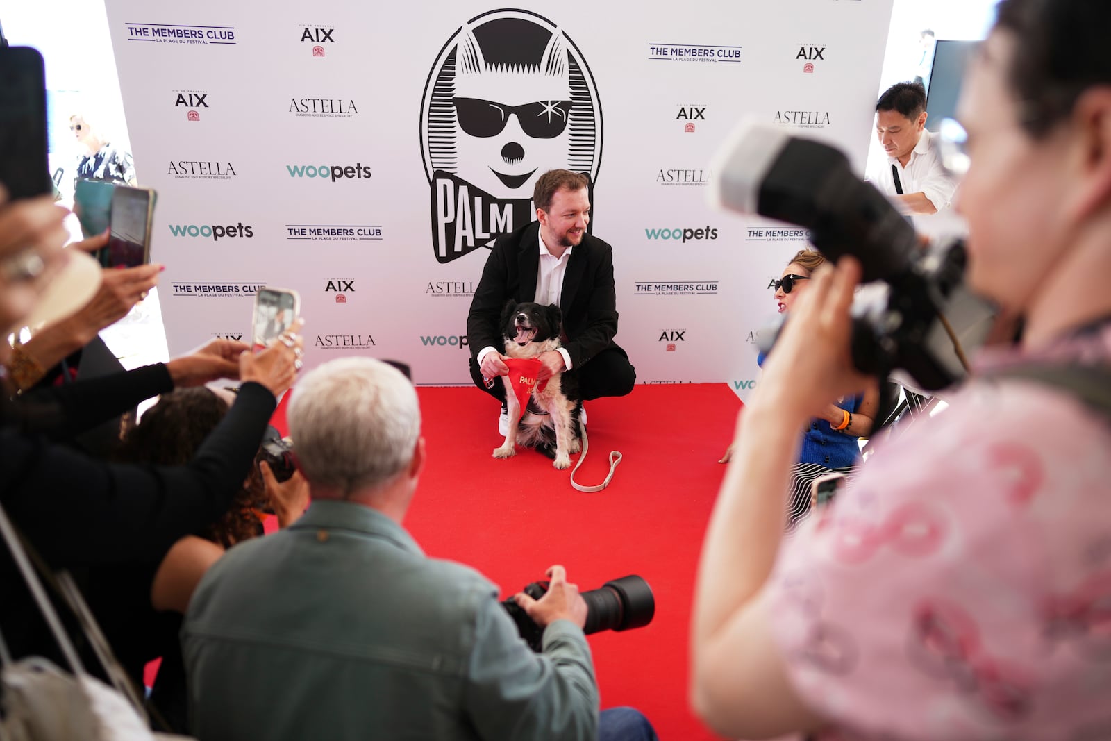 Anthony Provost, centre, and Perle pose for photographers after receiving the Palm Dog award on behalf of Panda, who could not attend, during the Palm Dog award ceremony at the 78th international film festival in Cannes, southern France, Friday, May 23, 2025. (AP Photo/Natacha Pisarenko)
