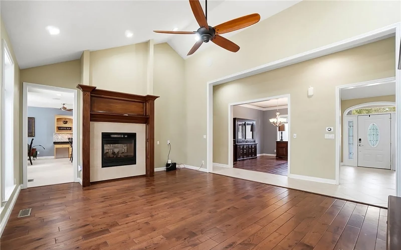 The great room has a vaulted ceiling, recessed lighting and a ceiling fan and hardwood flooring. There is a gas see through fireplace with a wood mantel. CONTRIBUTED