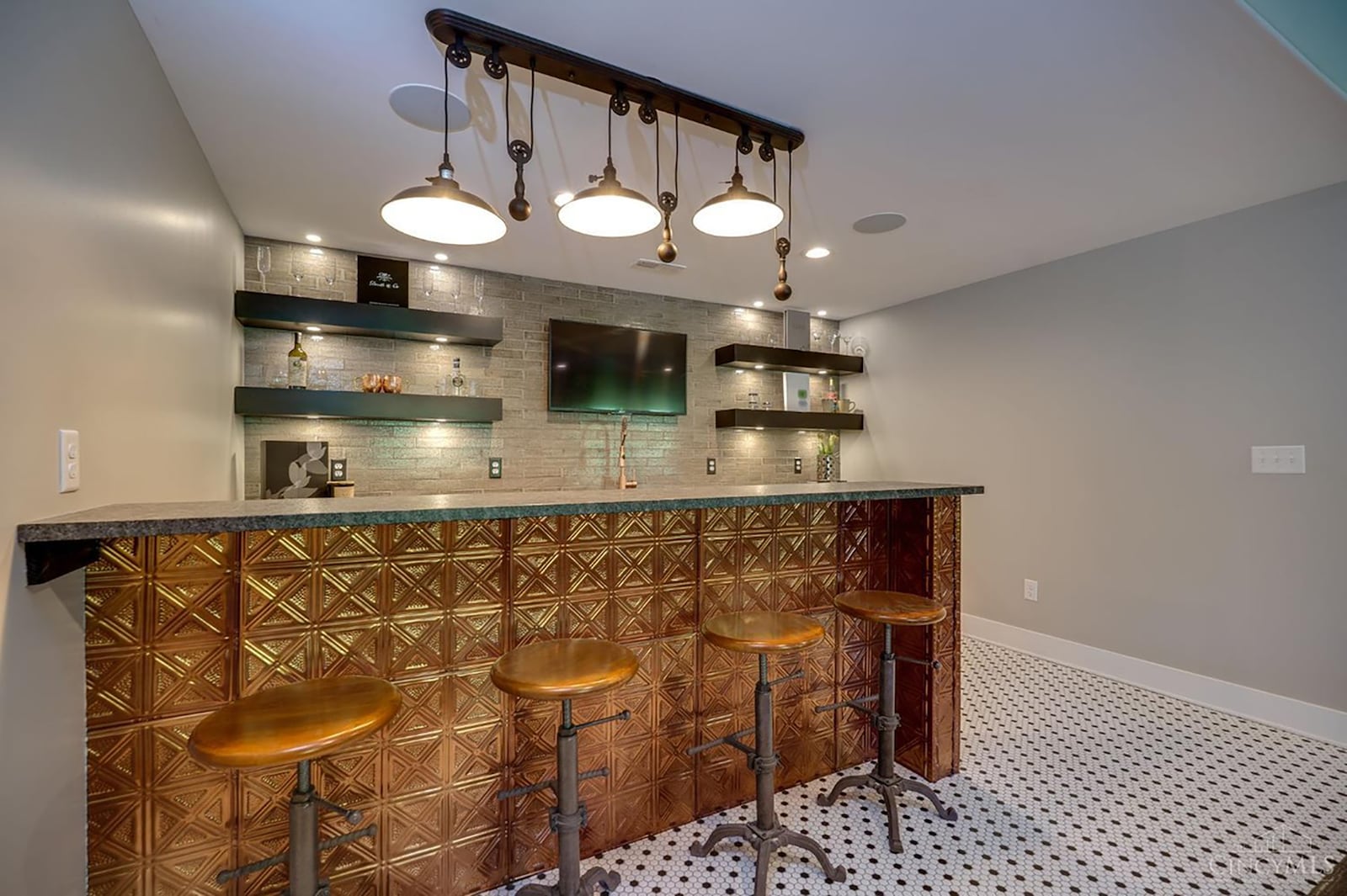 The finished basement has a recreation room with a custom wet bar featuring copper tiles and a custom lighting fixture. CONTRIBUTED