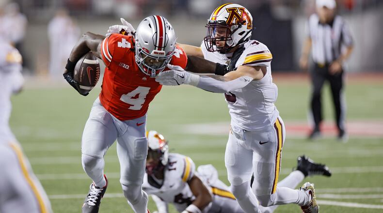 Ohio State receiver Jeremiah Smith, left, stiff arms Minnesota defensive back Koi Perich during the first half of an NCAA college football game Saturday, Oct. 4, 2025, in Columbus, Ohio. (AP Photo/Jay LaPrete)