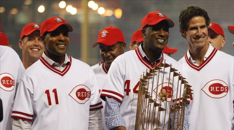 Former Reds Barry Larkin (11), Eric Davis (44) and Paul O'Neill pose with the World Series trophy during a 25th anniversary celebration of the 1990 World Series championship on Friday, April 24, 2015, at Great American Ball Park in Cincinnati. David Jablonski/Staff