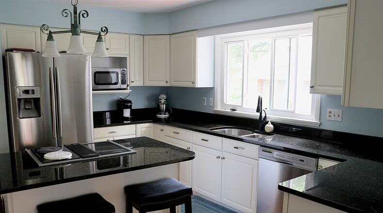 Double doors off the dining room open into the updated kitchen of this Oakwood bungalow. White cabinetry is complimented by dark granite countertops. Contributed photo