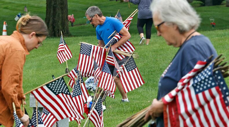 Volunteers were busy Saturday morning, May 18, 2024 placing over 3,000 American flags on the graves of service men and women interred in Ferncliff Cemetery for Memorial Day. Over 40 volunteers, including a large group from Werner Enterprises, placed flags on the central GAR (Civil War) mound, WWI section, WWII section and the Annex with more recent graves. The event was organized by Ferncliff Cemetery and Arboretum. BILL LACKEY/STAFF