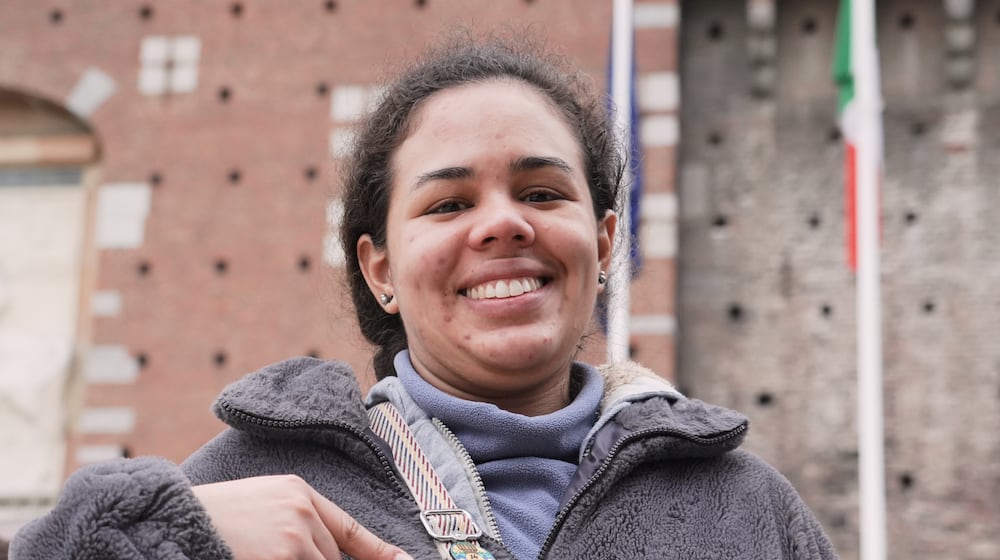 Isabella Botero, a Masters student studying in Milan, displays the YesMilano pins featuring city neighborhoods and landmarks that she has collected in recent days, at the 2026 Winter Olympics, in Milan, Italy, Wednesday, Feb. 11, 2026. (AP Photo/Mustakim Hasnath)