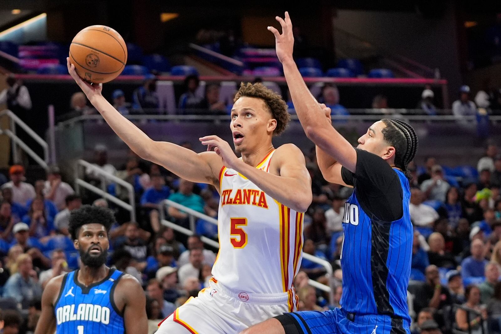 Atlanta Hawks guard Dyson Daniels (5) goes to the basket for a shot against Orlando Magic guard Anthony Black, right, during the first half of an NBA play-in tournament basketball game, Tuesday, April 15, 2025, in Orlando, Fla. (AP Photo/John Raoux)