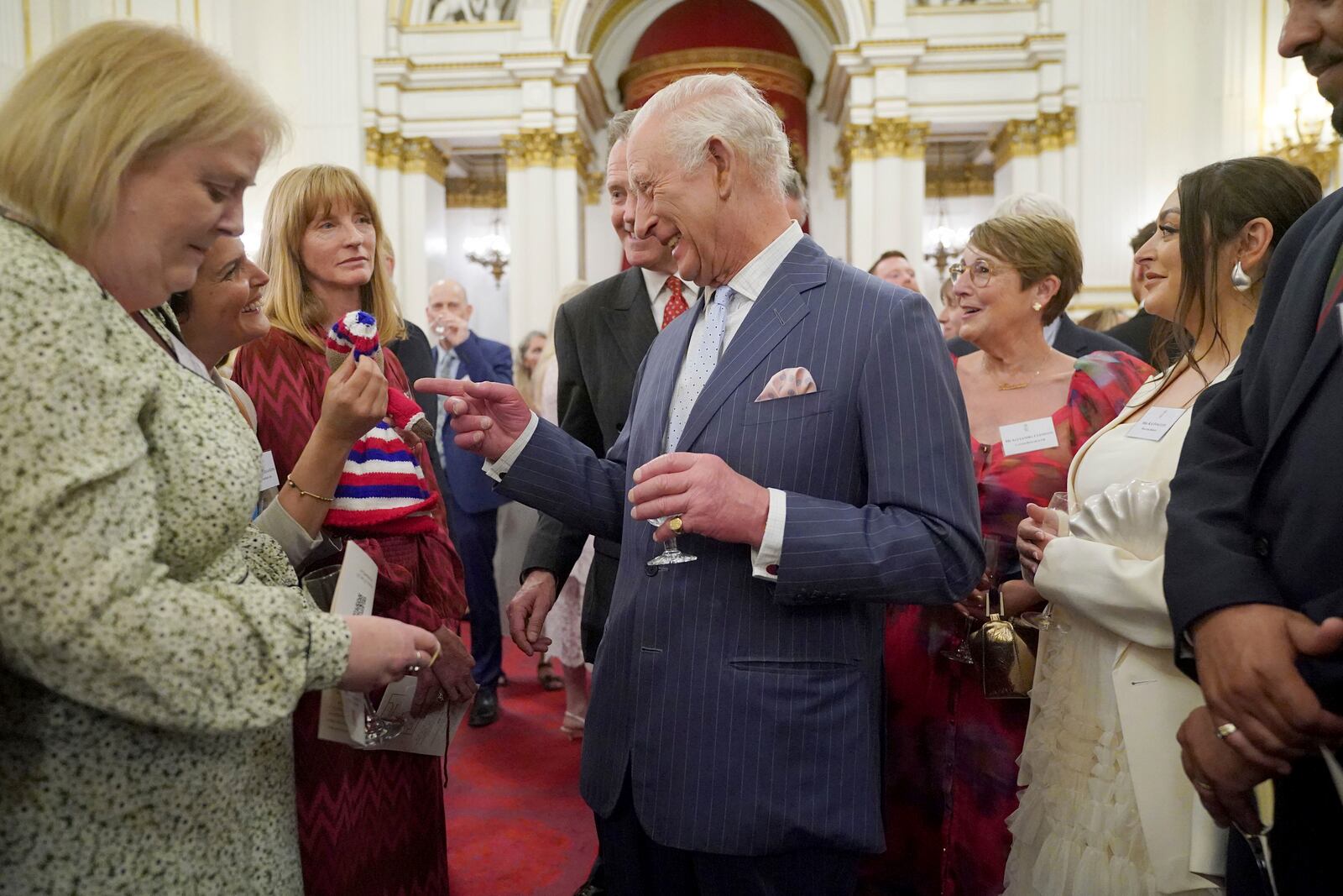 Britain's King Charles III speaks to guests during a reception in Buckingham Palace, London, in celebration of community-based initiatives raising awareness about cancer and supporting those living with cancer, Wednesday April 30, 2025. (Yui Mok/Pool Photo via AP)