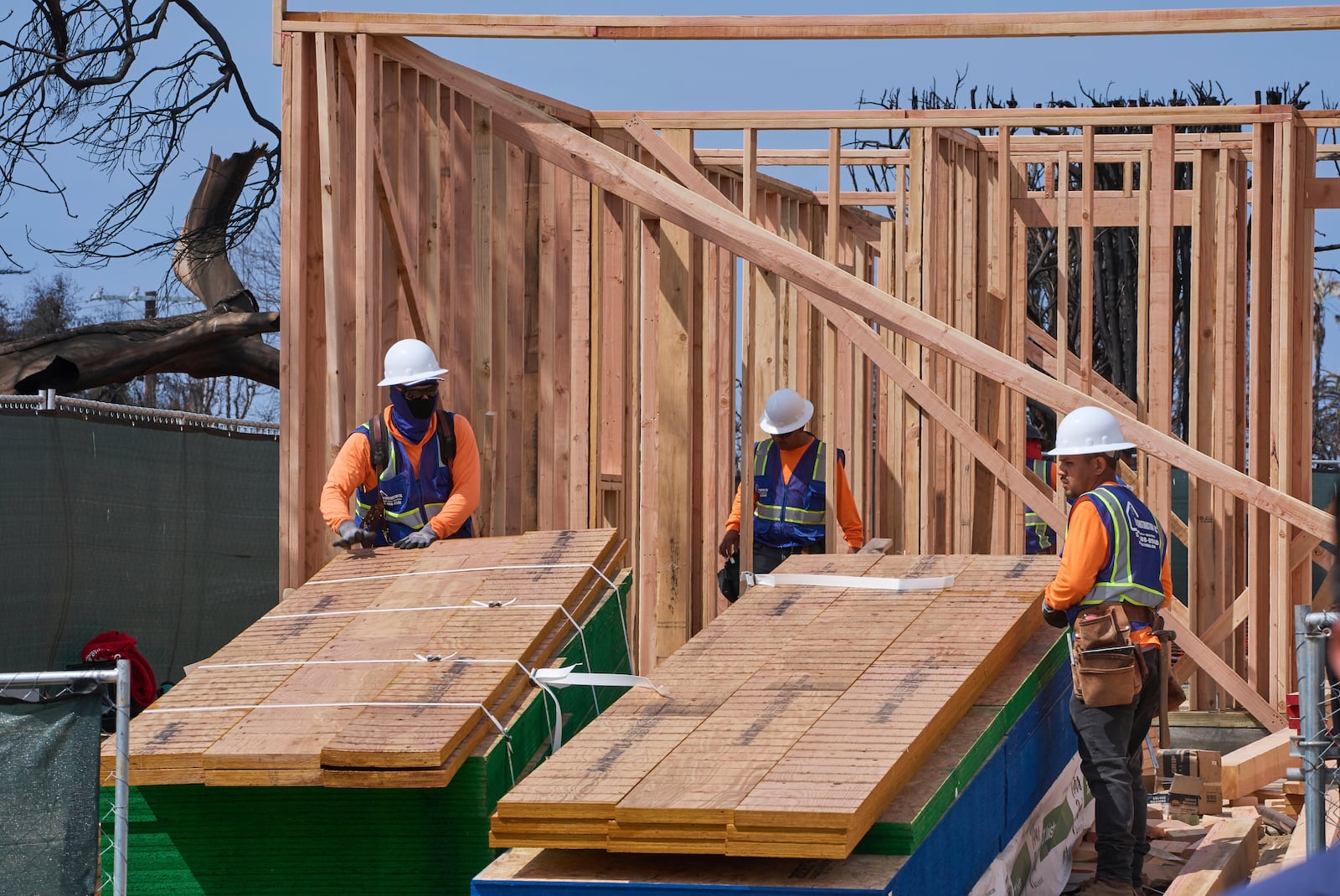 Workers rebuild a property destroyed by the Palisades Fire in the Pacific Palisades neighborhood of Los Angeles, Thursday, April 24, 2025. (AP Photo/Damian Dovarganes)