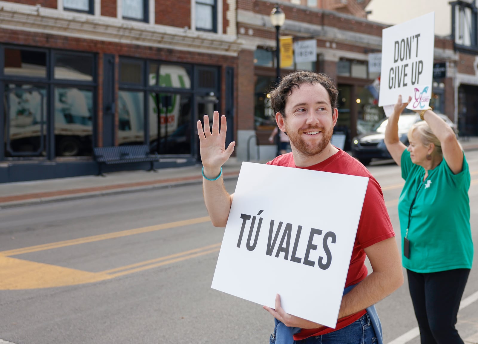Kelton Moore, center, holds up a sign with a positive message as part of an event held by a suicide prevention task force, Clark County Cares, to raise awareness of Suicide Prevention Awareness Month on Tuesday, September 16, 2025, in Springfield. JOSEPH COOKE/STAFF