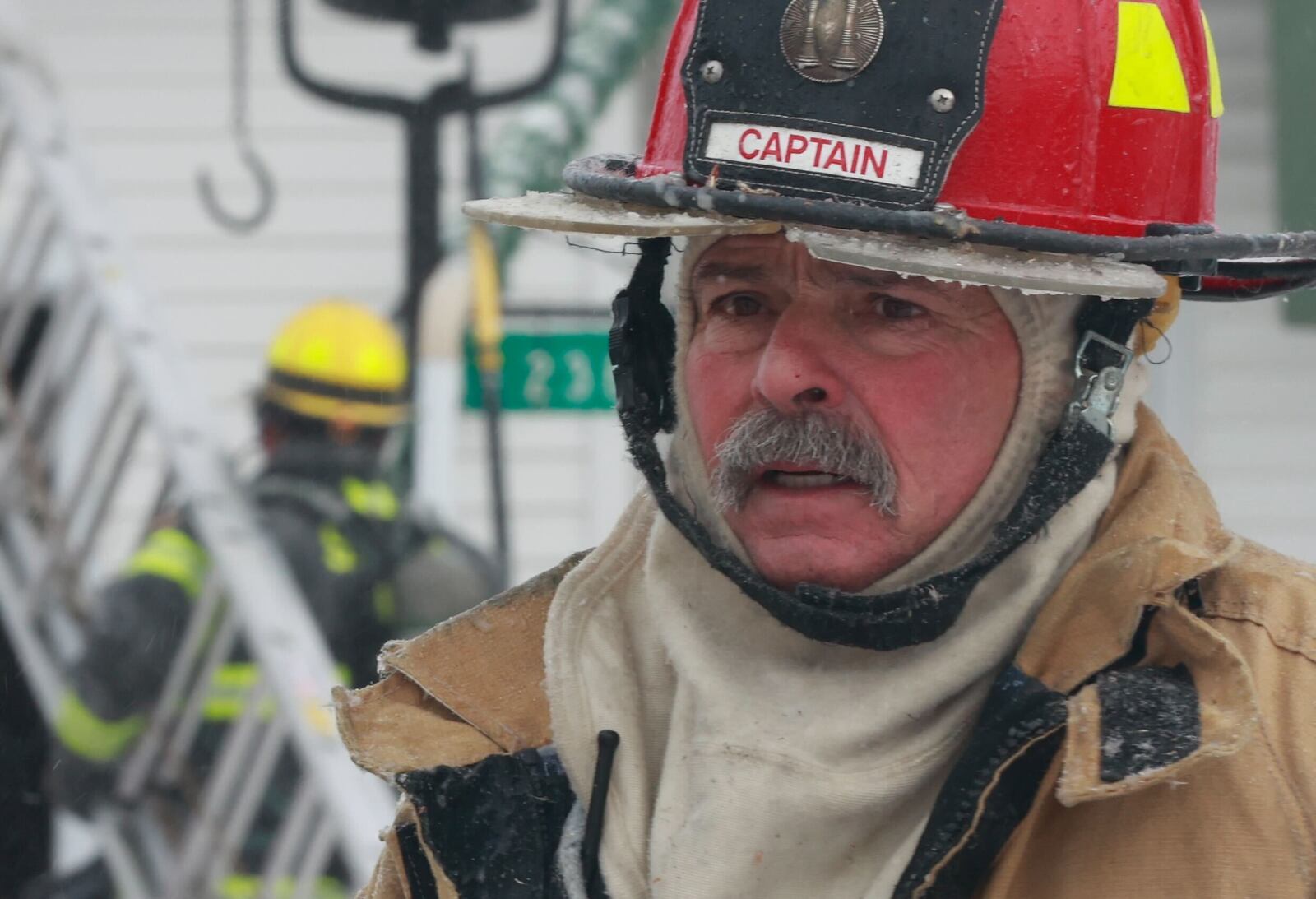 A fire captain is coated with ice at a house fire in the 200 block of Green Acres Drive Friday. BILL LACKEY/STAFF
